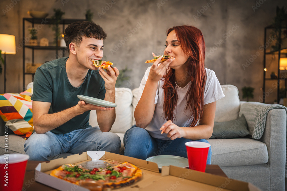 Adult couple boyfriend and girlfriend hanging out at home eat pizza Adult couple boyfriend and girlfriend hanging out at home eat pizza