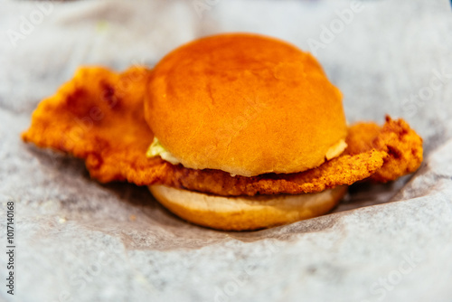 A fried fish fillet sandwich on white parchment paper