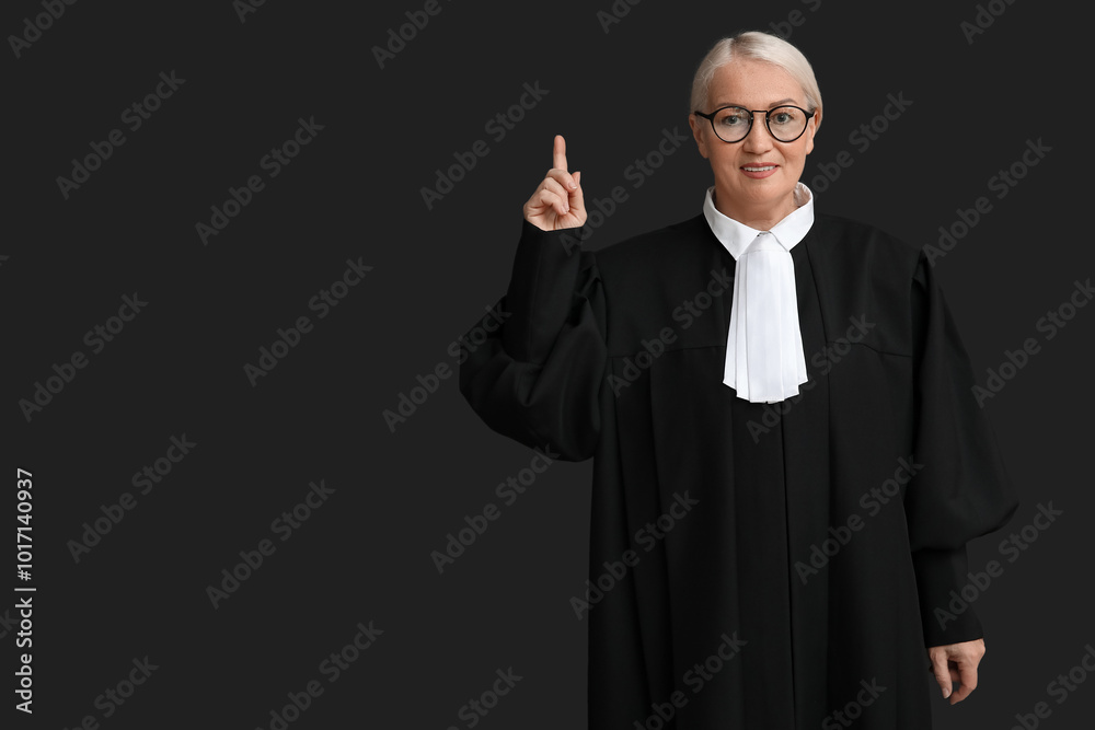 Mature female judge pointing at something on black background Mature female judge pointing at something on black background