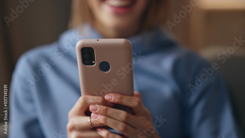 Excited girl reading message on cellphone at apartment closeup. Smiling woman