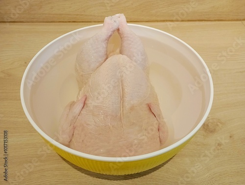 Fotografija Defrosting Chicken In a Bowl of Water on The Kitchen Table