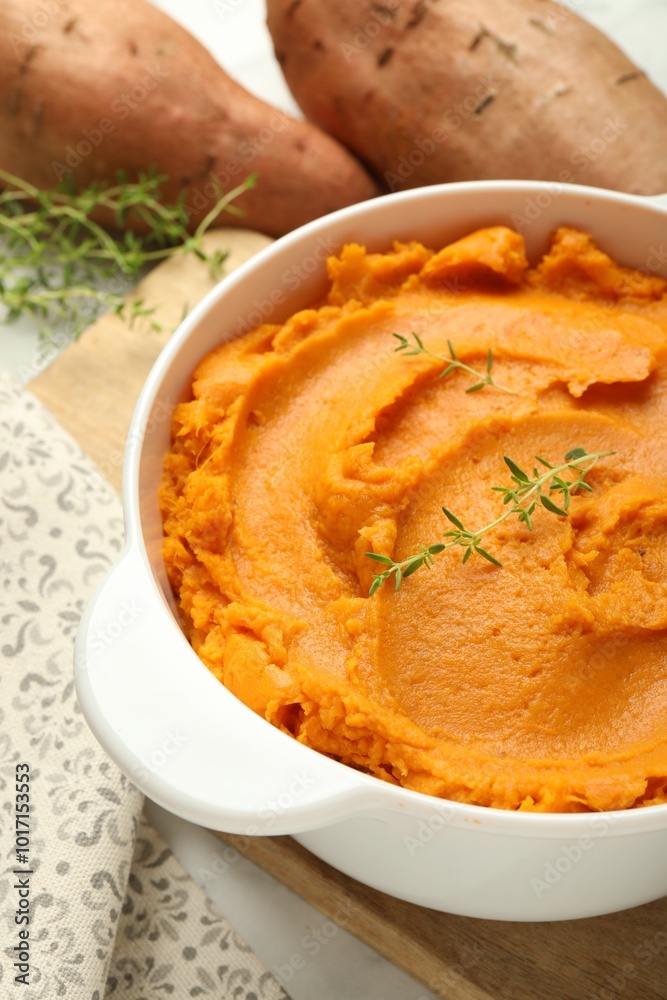 Delicious mashed sweet potatoes in pot and vegetables on table, closeup Delicious mashed sweet potatoes in pot and vegetables on table, closeup
