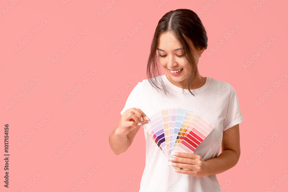 Beautiful young woman with different palette samples on pink background