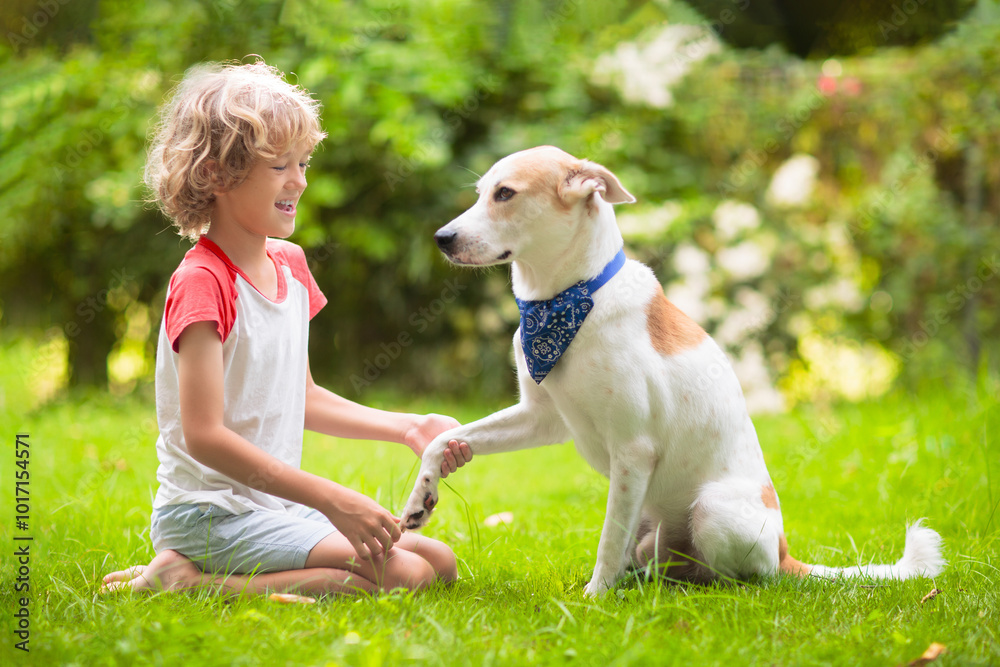 Child playing with a dog in sunny summer garden Child playing with a dog in sunny summer garden