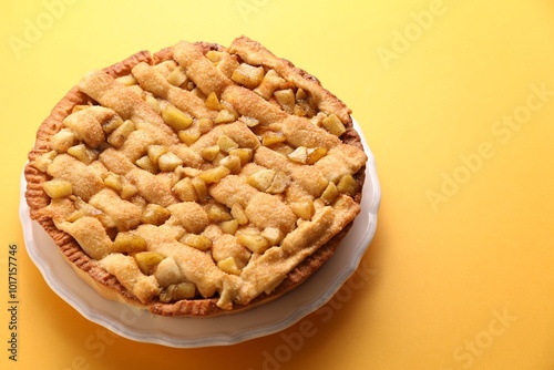 Tasty homemade apple pie on yellow background. Space for text