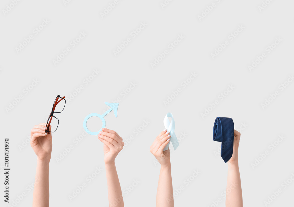 Female hands with eyeglasses, male sign, light blue ribbon and tie on white background. Prostate cancer concept
