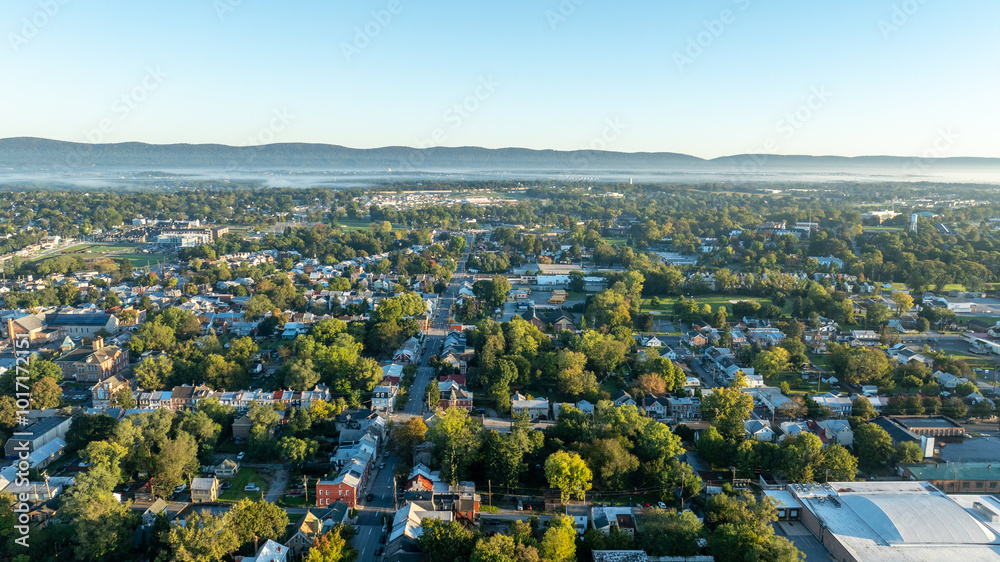 Αυτοκόλλητο Aerial view of Carlisle, PA, showcasing a mix of residential, commercial buildings, and tree-lined streets under a clear morning sky