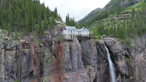 Powerhouse and Bridal Veil Falls near Telluride, Colorado. Flyby shot is a rotating pan shot showing the structure, waterfall, and cliffs of the area.