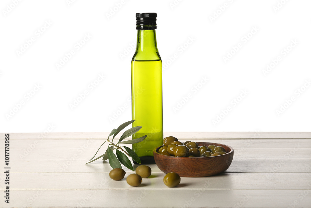 Bottle of fresh olive oil on wooden table against white background Bottle of fresh olive oil on wooden table against white background