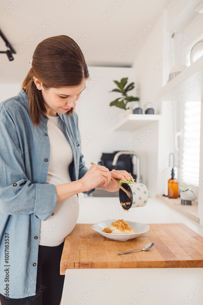 Young pregnant adult woman doing everyday things at home. Cooking, eating, sitting on couch, preparing things for the child.