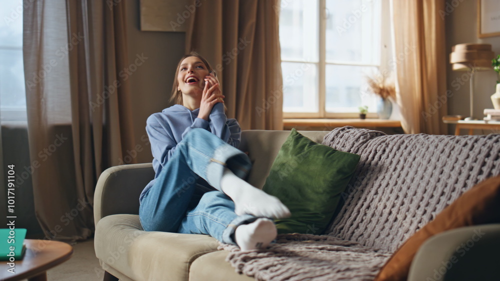 Carefree teenager answer call mobile phone on couch looking cheerful. Happy lady Carefree teenager answer call mobile phone on couch looking cheerful. Happy lady