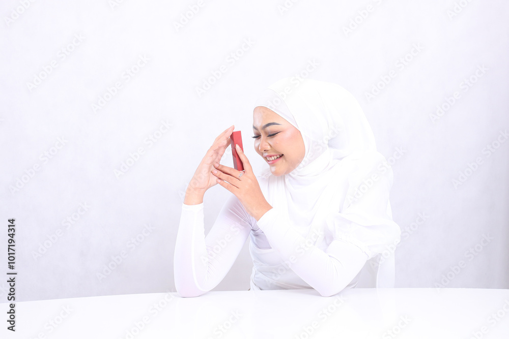 closeup lip makeup Beautiful young veil woman indonesia laughing close eyes both hands holding lipstick product container isolated on white background. cosmetics concept, lipstick mock up container closeup lip makeup Beautiful young veil woman indonesia laughing close eyes both hands holding lipstick product container isolated on white background. cosmetics concept, lipstick mock up container