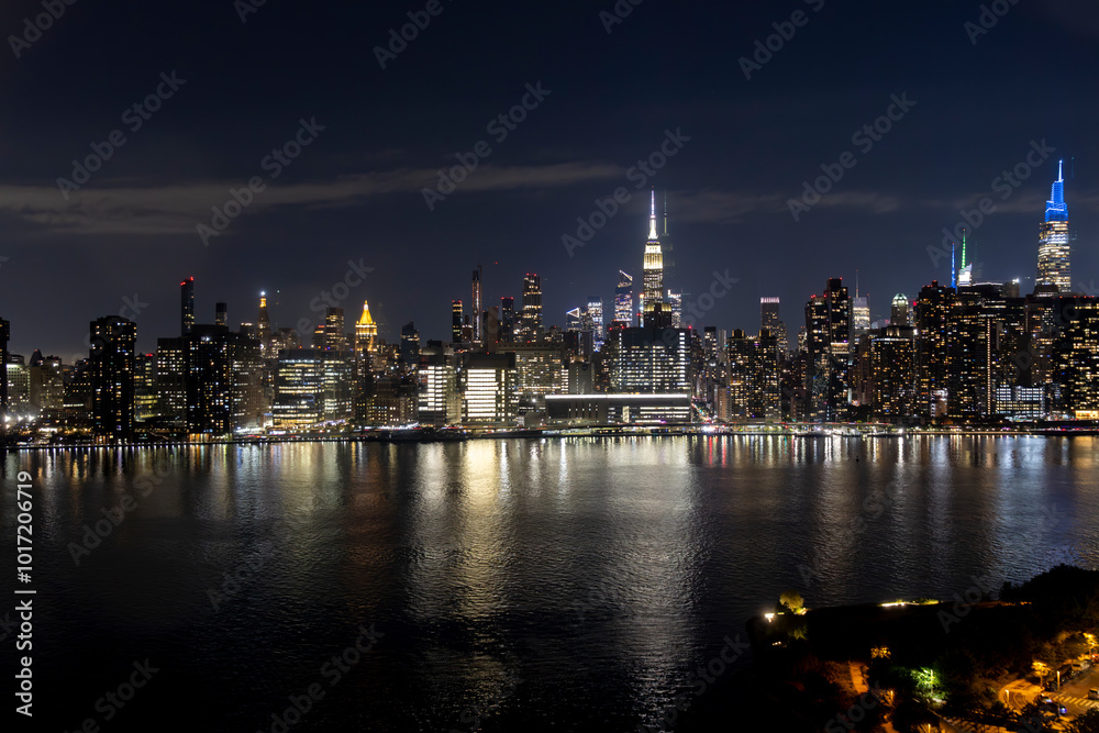Illuminated skyline of New York City at night showcasing colorful lights along the waterfront Illuminated skyline of New York City at night showcasing colorful lights along the waterfront