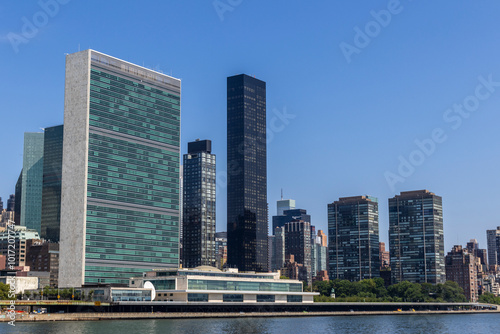 New York, NY, USA - 08,2024:View of the United Nations headquarters building along the East River in New York City under a clear blue sky