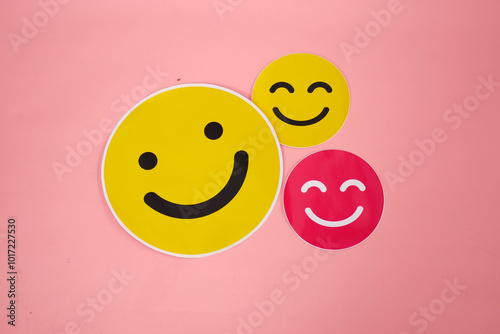 Yellow and pink smile emoticon sticker on pink background