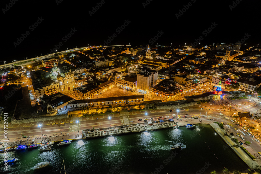Fototapeta premium Beautiful Aerial view of the walled city of Cartagena de Indias in Colombia. Its Clock Tower entrance, the plaza, the sanctuary and the Domus Dei at night