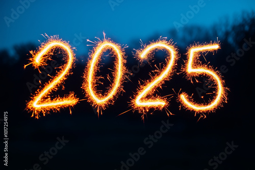 Long exposure of someone writing the year 2025 with sparklers in the night sky for the New Years celebration