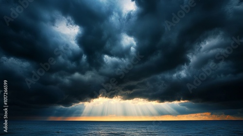 Dramatic sun rays piercing storm clouds above ocean symbolize hope after storm.