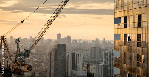 Fotografie Sunset light reflecting off a modern skyscraper,in downtown Manila,Luzon,Philippines