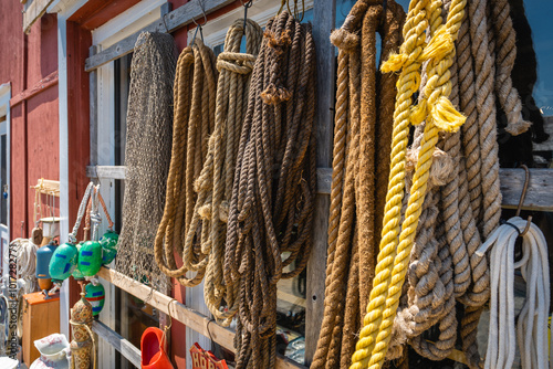 Rope of various kinds hang on the side a marine outfitter photo