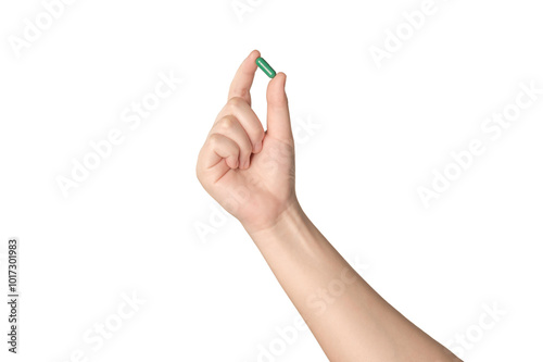 Hand holding green capsule pill isolated on white background. photo