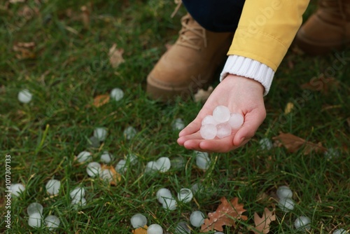 Woman holding hail grains after thunderstorm outdoors, closeup