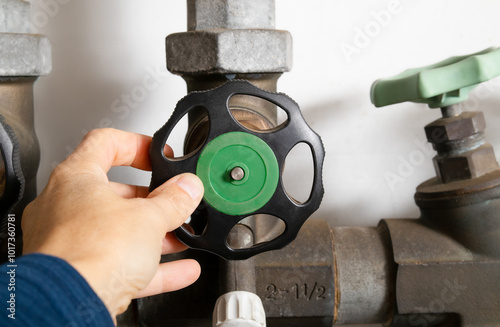 Plumber using backflow shut off valve or backwater valve. Emergency water shut-off preventing contamination of drinking water from sewage backup or bacteria. Selective focus. Lucerne, Switzerland