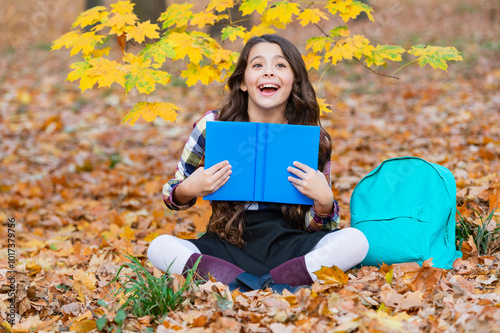 Back to school. School education. School girl reading book outdoor. Teen girl reading in the autumn park. Education and knowledge. Knowledge day. Self education. Autumn book. Funny moment