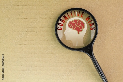 magnifying glass with brain icon and the word Cognitive bias. systematic patterns of deviation from norm or rationality in judgment photo