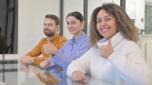 Multi Ethnic Teammates with Thumbs Up Looking at Camera in Office