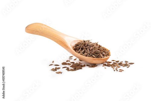 Dried cumin seeds in a wooden spoon on a white background. A cooking seasoning popular in the cuisine of Asia and the Middle East