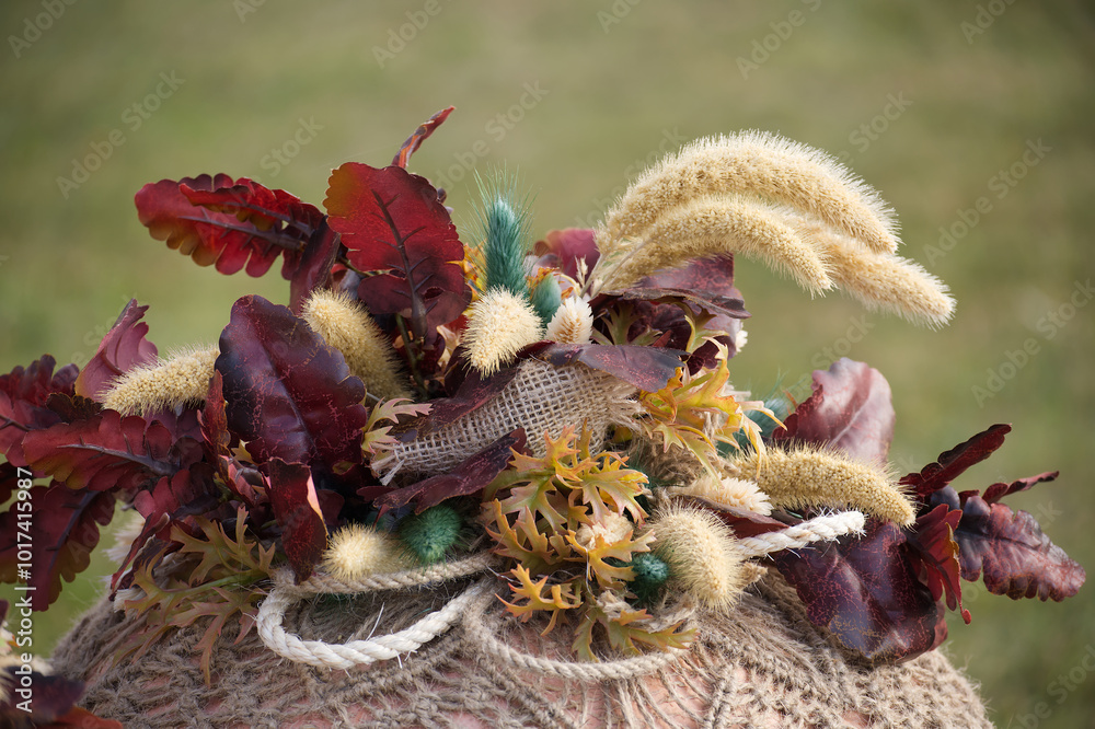 Fototapeta premium Rustic autumn bouquet with burlap and leaves