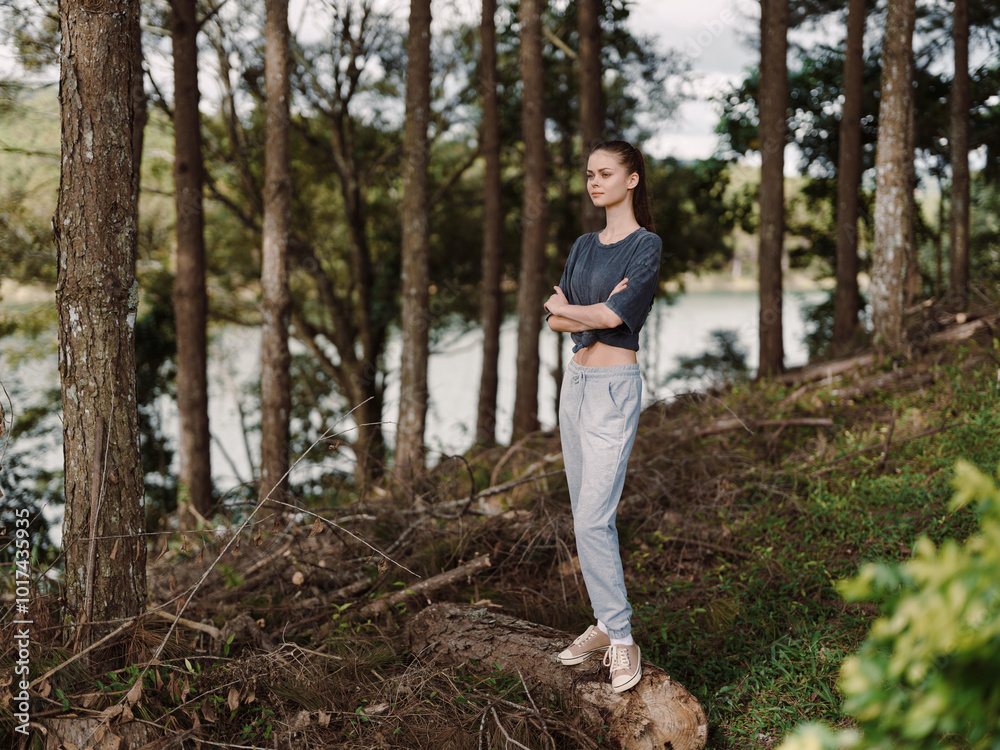 Thoughtful young woman standing by the trees near a serene lake, enjoying nature and reflecting on her surroundings Wellness and mindfulness concept Thoughtful young woman standing by the trees near a serene lake, enjoying nature and reflecting on her surroundings Wellness and mindfulness concept
