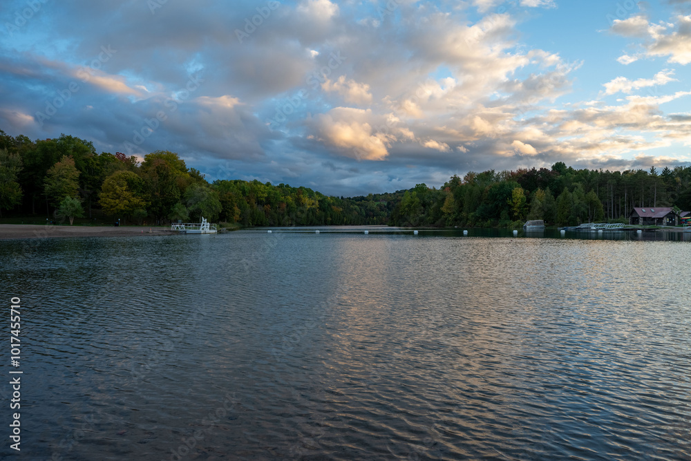 Green Lakes State Park in Syracuse offers a peaceful view of its crystal-clear waters, framed by lush trees. The sunset glow casts a soft light on the serene lake, making it a perfect spot for reflect Green Lakes State Park in Syracuse offers a peaceful view of its crystal-clear waters, framed by lush trees. The sunset glow casts a soft light on the serene lake, making it a perfect spot for reflect