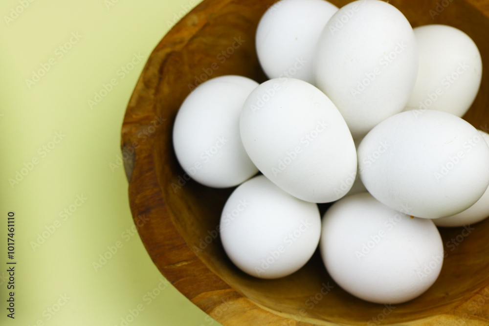 Raw Eggs from white leghorn chicken on wooden bowl. Selective focus with isolated background and copy space. Raw Eggs from white leghorn chicken on wooden bowl. Selective focus with isolated background and copy space.
