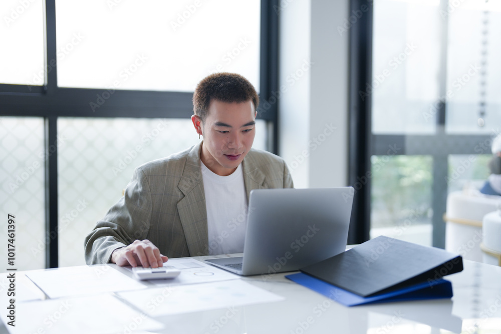 Attractive confident millennial Asian Business man using laptop computer and professional working investor start up project business planning in office. Attractive confident millennial Asian Business man using laptop computer and professional working investor start up project business planning in office.
