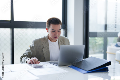 Attractive confident millennial Asian Business man using laptop computer and professional working investor start up project business planning in office.