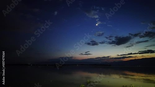 Footage of landscape, sky, and clouds at sunset beside a river stream - Kwan Phayao, Thailand