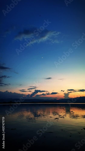 Footage of landscape, sky, and clouds at sunset beside a river stream - Kwan Phayao, Thailand