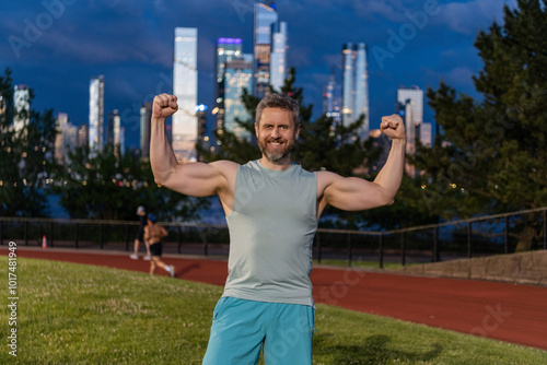 Biceps concept. Athlete show biceps and triceps. Man flex arms with biceps. Strong muscular man sportsman. Sport workout outdoor. Sportsman after training. Man doing sport