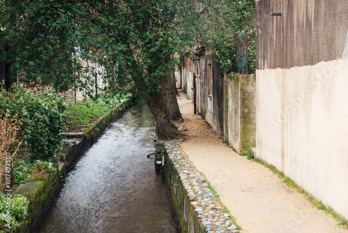 Petite rivière en ville. Ru urbain. Aménagement de berge pour piéton. Cours d'eau aménagé. photo