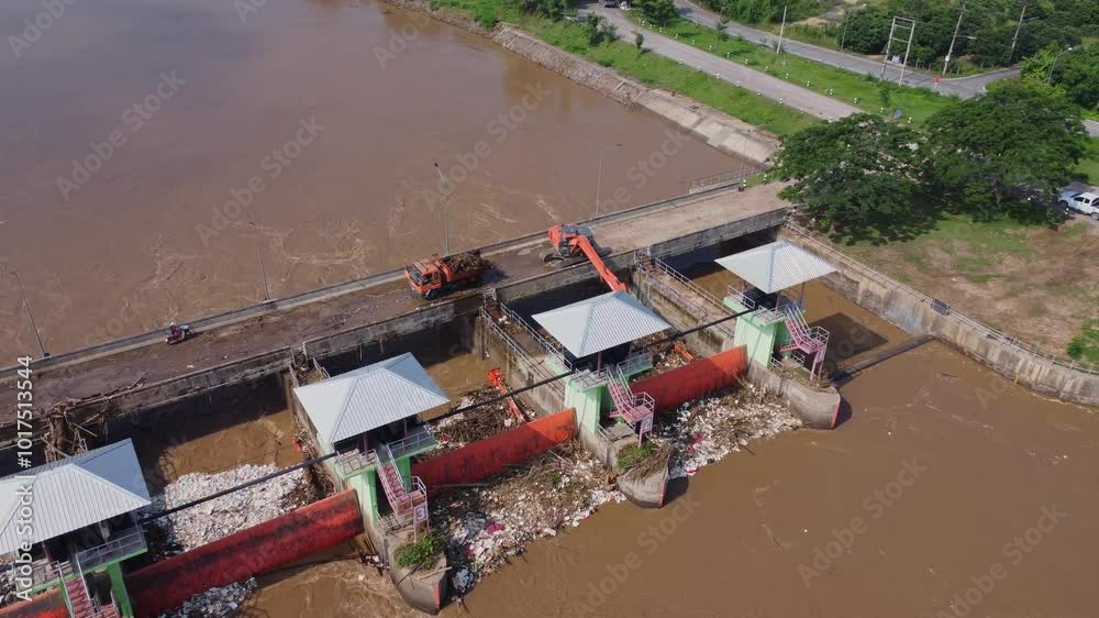Aerial view of the dam's floodgates with rapid flow of water in the rainy season. Dam water release, dam overcapacity after heavy rain. Aerial view of the dam's floodgates with rapid flow of water in the rainy season. Dam water release, dam overcapacity after heavy rain.