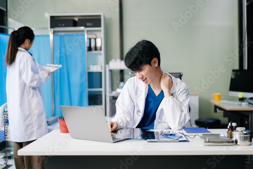 Doctor analyzing patient data on tablet in clinical lab. Medical professional in hospital with laptop, blood samples