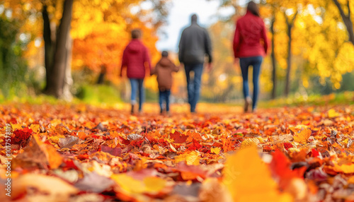 Fototapeta Naklejka Na Ścianę i Meble -  Family hiking in forest walking on fallen autumn leaves