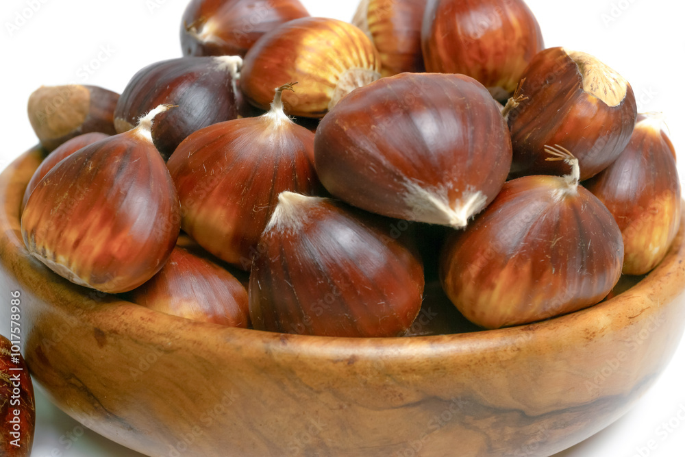 fresh seasonal chestnuts harvested in the field in a wooden bowl isolated on a white background and copy space fresh seasonal chestnuts harvested in the field in a wooden bowl isolated on a white background and copy space