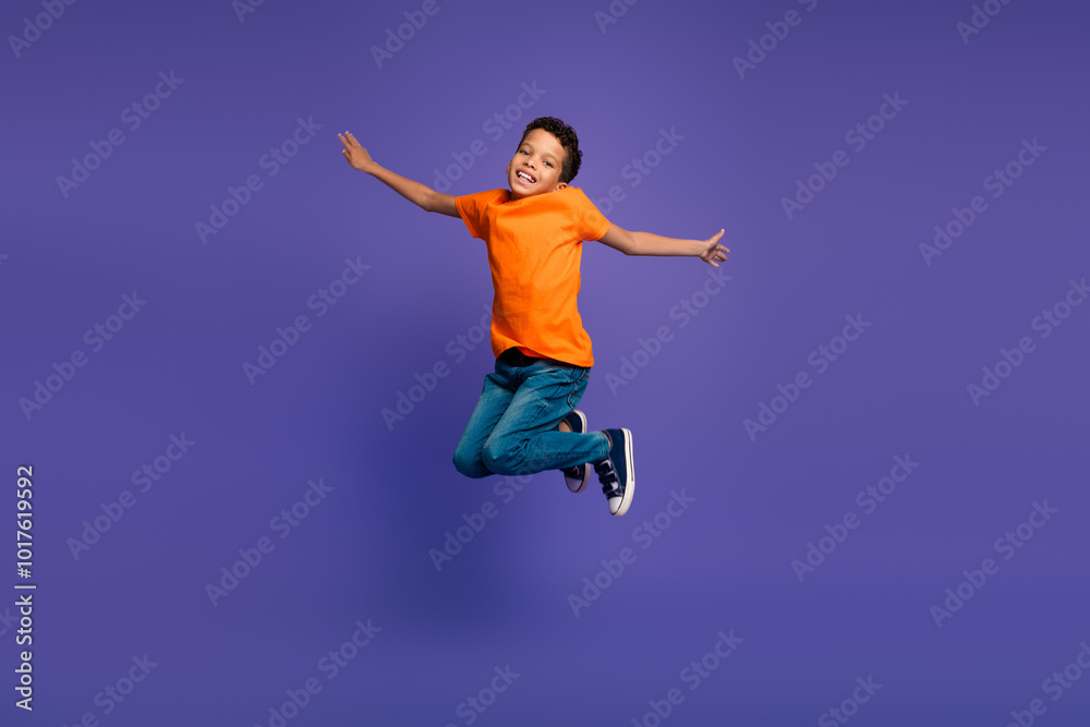 Full length portrait of nice little schoolchild jumping isolated on purple color background Full length portrait of nice little schoolchild jumping isolated on purple color background
