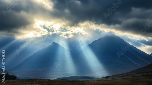 Dramatic clouds over a mountain range with sunlight breaking through photo