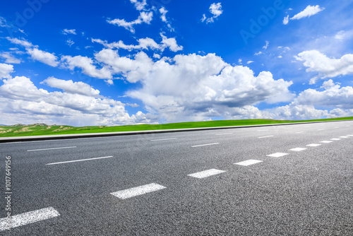 Asphalt highway road and green meadow nature landscape under blue sky. car background.