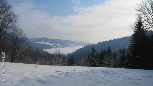 Snow-covered hills under a dreamy winter sky in a tranquil mountain landscape