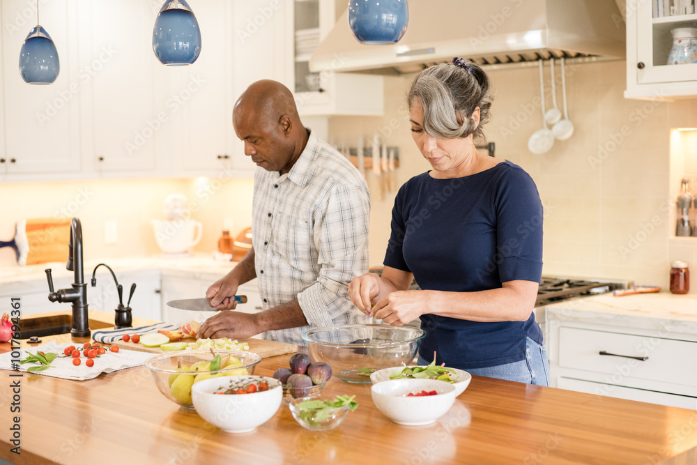 Couple preparing a meal together in kitchen Couple preparing a meal together in kitchen